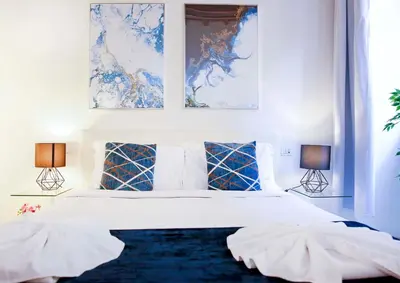 a bedroom with a large white bed with two lamps at Mario Suite Spagna in Rome