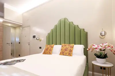 a bedroom with a large bed with a green headboard at Vatican Loft - Liberty Collection in Rome