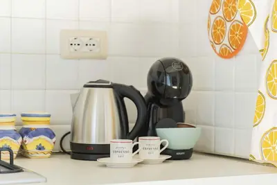 a kitchen counter with three cups and a coffee maker at Appartamento panoramico vicino al Colosseo in Rome