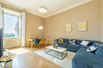 a living room with a blue couch and a table at Appartamento panoramico vicino al Colosseo in Rome