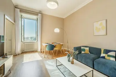 a living room with a blue couch and a table at Appartamento panoramico vicino al Colosseo in Rome