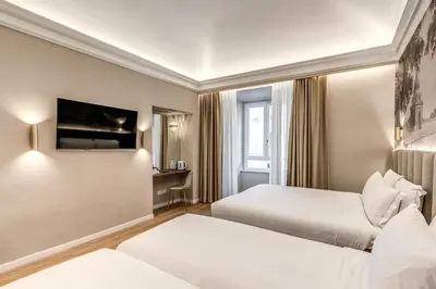 a hotel room with two beds and a desk at Lumi Hotel in Rome