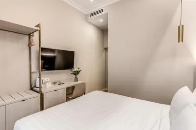 a bedroom with a white bed and a tv at Lumi Hotel in Rome