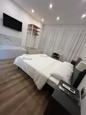 a bedroom with a white bed and a television at Suite 98 in Rome