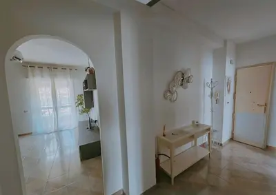 a large white room with a table and an archway at Erika's Apartment in Rome