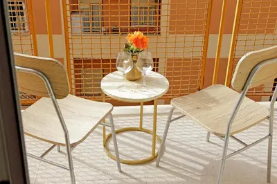 a table with two chairs and a vase with flowers on it at Golden Apartment in Rome