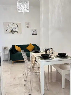 a dining room with a white table and a green couch at Casa Giulia in Rome