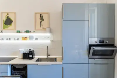 a white kitchen with a refrigerator and a sink at San Lorenzo Style Apartment in Rome