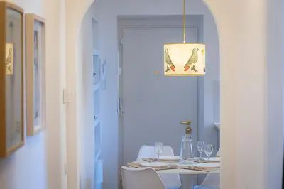 a dining room with a table and a chandelier at San Lorenzo Style Apartment in Rome