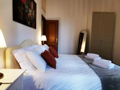a bedroom with a bed with white sheets and red pillows at Key apartments Vatican Flat in Rome