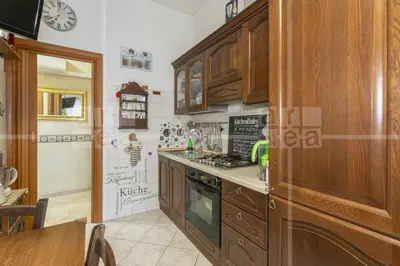 a kitchen with wooden cabinets and a stove top oven at Trastevere in Station in Rome