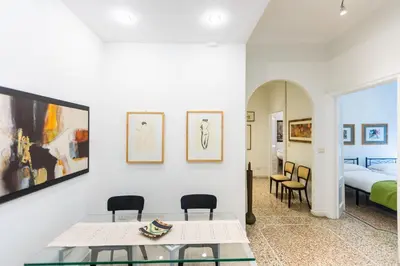 a living room with a table and chairs and a bed at Clodia 5 by Rental in Rome in Rome