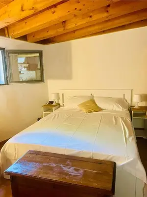 a bedroom with a white bed with a wooden ceiling at Minicasa Vatican in Rome
