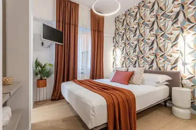 a bedroom with a bed and a wall with a tree pattern at Vatican Modern Apartment 5 min Metro A - Terrestre in Rome