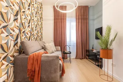 a living room with a chair and a potted plant at Vatican Modern Apartment 5 min Metro A - Terrestre in Rome