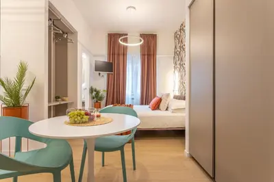 a room with a table and chairs and a bed at Vatican Modern Apartment 5 min Metro A - Terrestre in Rome