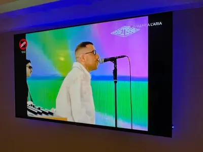 a man speaking into a microphone on a television screen at Historical Houses in Rome
