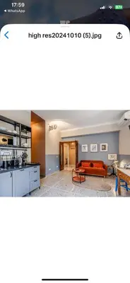 a screenshot of a kitchen and living room with a couch at Atelier Gianicolo Suite in Rome