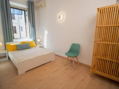 a bedroom with a bed and a chair and a window at 2BDR Testaccio Sweet Home in Rome