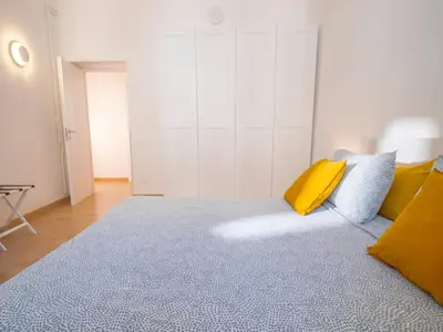 a bedroom with a bed with a blue rug and yellow pillows at 2BDR Testaccio Sweet Home in Rome