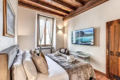 a bedroom with a bed and a couch and a window at Casa Navona Apartments in Rome