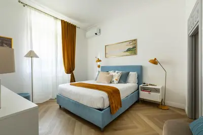 a bedroom with a blue and white bed and a window at YCH-Belle Epoque House in Rome