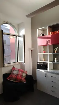 a living room with a black couch and a window at B&B Garbatella-Sotto l'arco del Lotto 28 in Rome