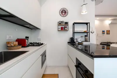 a kitchen with white walls and black counter tops at Elegante Appartamento presso Vaticano in Rome