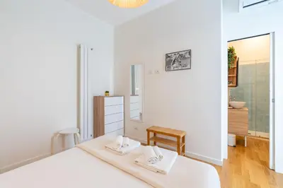 a white bedroom with a bed and a bathroom at Elegante Appartamento presso Vaticano in Rome