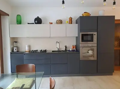 a kitchen with blue cabinets and a glass table at Casa Nisio - Gemelli comoda e accogliente in Rome