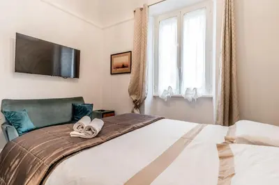 a bedroom with a bed with a television on the wall at Villa Borghese Gallery Rooms in Rome