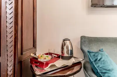 a tray with a tea kettle on a table next to a chair at Villa Borghese Gallery Rooms in Rome