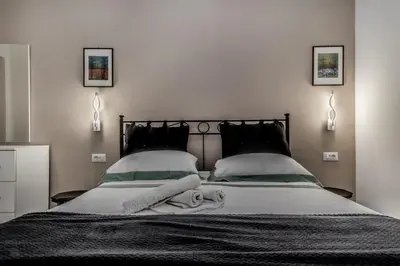 a bedroom with a large bed with two pillows at Villa Borghese Gallery Rooms in Rome