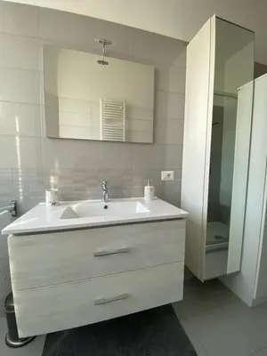 a white bathroom with a sink and a mirror at Lola's house in Rome