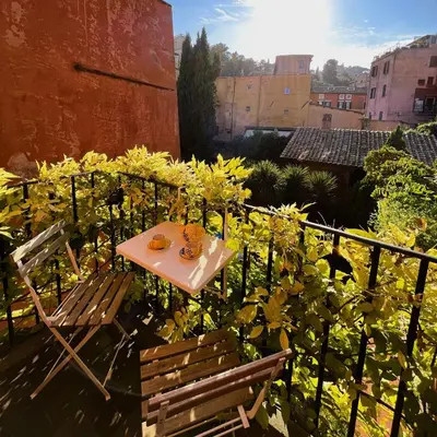 a small table and chairs sitting on a balcony at The Gem - Trastevere Cozy Retreat with pool in Rome