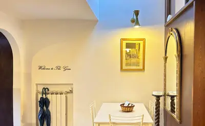 a dining room with a white table and chairs at The Gem - Trastevere Cozy Retreat with pool in Rome