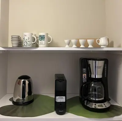 a shelf with a coffee maker and affeepot and cups at La Petite Urbana Apartment in Rome