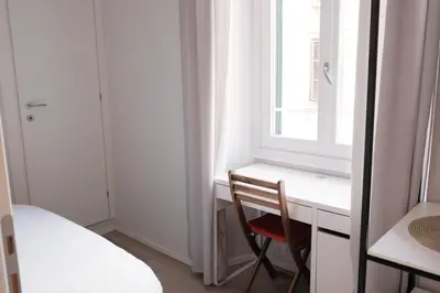 a bedroom with a desk and a chair next to a window at Numi B&B in Rome