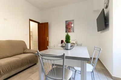 a living room with a table with chairs and a couch at Casa Ausilia in Rome