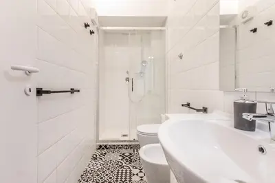 a white bathroom with a toilet and a sink at Sapienza Apt - Modern House in Piazza Bologna in Rome