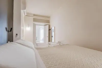 a white bedroom with a large bed and a window at CasaTrastevere Alessio&Simone in Rome
