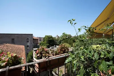 a balcony with a bunch of plants on a building at Colosseo The Family Home in Monti in Rome