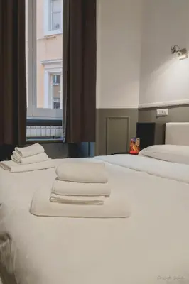 two beds with white towels on top of them at WE LOVE ROMA Guest House in Rome
