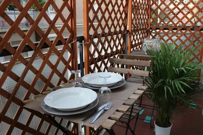 a wooden table with plates and silverware on a patio at The house of St. Peter in Rome