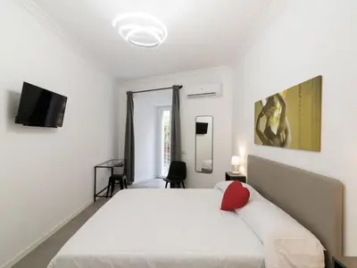 a bedroom with a white bed with a red pillow at Apartment Welcome Rome by Interhome in Rome