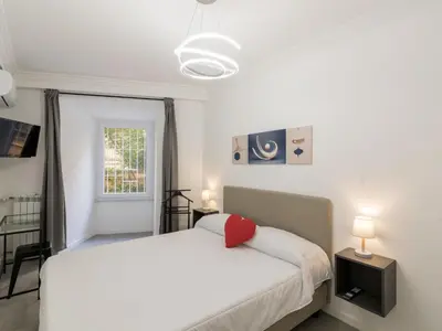 a bedroom with a white bed with a red pillow at Apartment Welcome Rome by Interhome in Rome