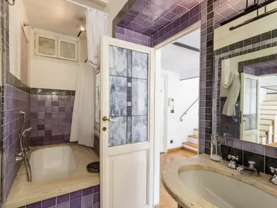 a bathroom with a tub and purple tiles at Apartment Marsicum by Interhome in Rome