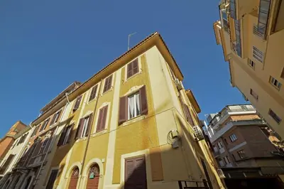 a yellow building in the middle of two buildings at Lucia Casa Vacanze Ponte Milvio in Rome