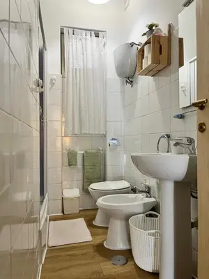 a white bathroom with a toilet and a sink at VerdePigna Apartment in Rome