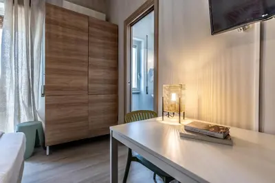 a room with a table with a lamp on it at Dafne Rooms un soggiorno energico e pieno di vita in Rome